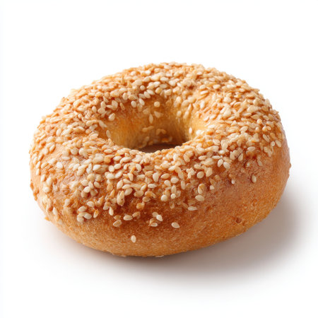 A freshly baked sesame seed bagel resting on a white background, showcasing its golden crust and soft interior, ideal for breakfast or a satisfying snack.の素材