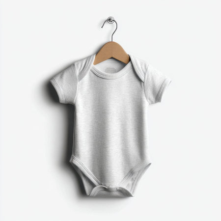 A minimalist plain white baby bodysuit hanging on a wooden hanger, ideal for showcasing designs or creating mockups in baby clothing projects.の素材