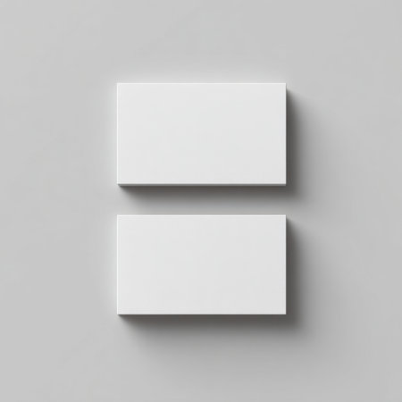 This image showcases two blank business cards arranged vertically on a smooth grey surface, perfect for creative branding and design applications.の素材