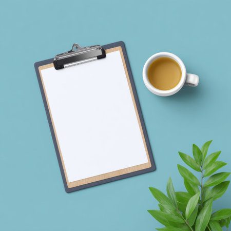 A minimalistic flat lay of a blank clipboard and a coffee cup against a soothing blue background, perfect for business planning and creative projects.の素材