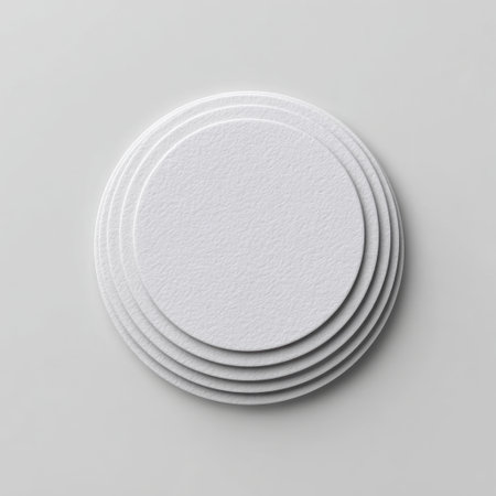 A series of white circular paper discs stacked on a minimalist surface, providing a clean and elegant backdrop for various creative and artistic projects.の素材