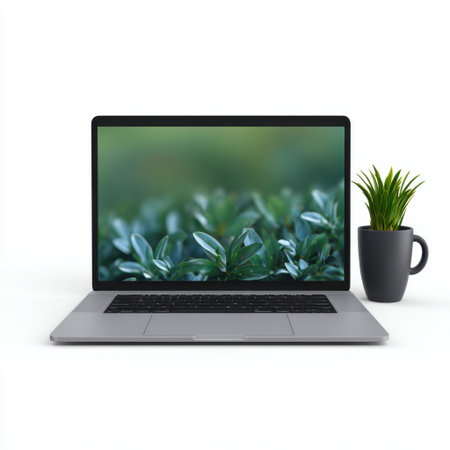 A sleek laptop rests on a clean desk beside a small potted plant, complemented by a soft focus of lush greenery in the background, symbolizing productivity.の素材