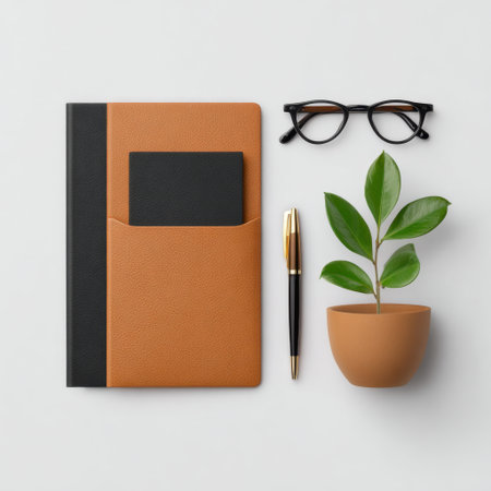 A chic workspace layout featuring a stylish notebook, elegant pen, reading glasses, and a vibrant plant in a pot, perfect for inspiration and productivity.の素材