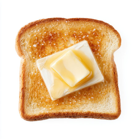 A close-up image of a toasted bread slice topped with a pat of melting butter, perfect for a delicious breakfast or snack. The rich texture and warm color create an inviting atmosphere for food lovers.の素材