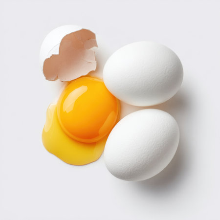 Captivating image of a fresh egg with a broken shell and vibrant yellow yolk, perfect for culinary projects, food blogs, or kitchen inspirations.の素材