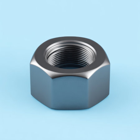 A close-up view of a metallic nut resting on a light blue background, perfect for showcasing industrial design, mechanics, or hardware projects.の素材
