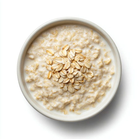 A delicious bowl of creamy oatmeal topped with fresh oats, perfect for a healthy breakfast or a nutritious snack option, displayed on a clean white background.の素材