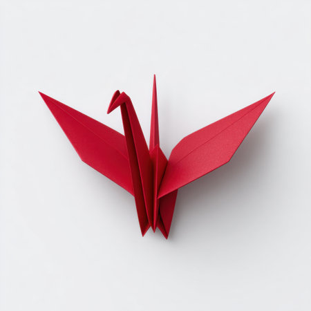 This image features an elegant red origami crane delicately crafted from paper, showcasing artistic design on a clean white background.の素材