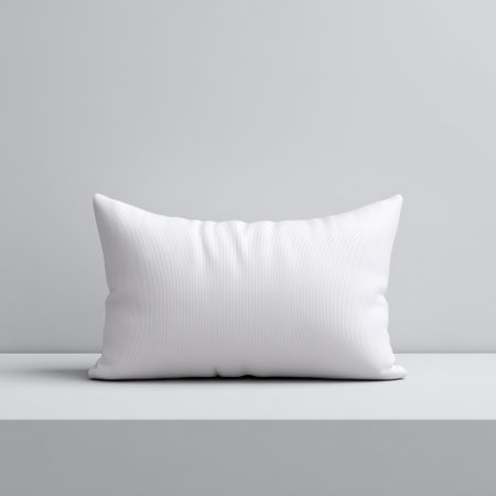 This image features a soft white pillow resting on a minimalistic white table, offering a serene and elegant touch to any interior design project.の素材