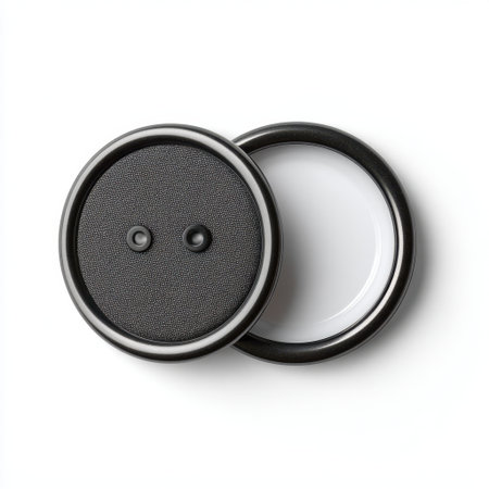 A high-quality image featuring a textured button with two holes and a sleek black rim on a white background, ideal for fashion and design projects.の素材