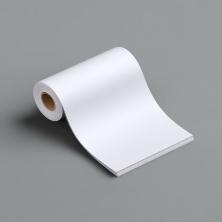 A clean and blank white sheet of paper lies rolled on a gray surface, providing a versatile backdrop for creative projects and design inspiration.の素材