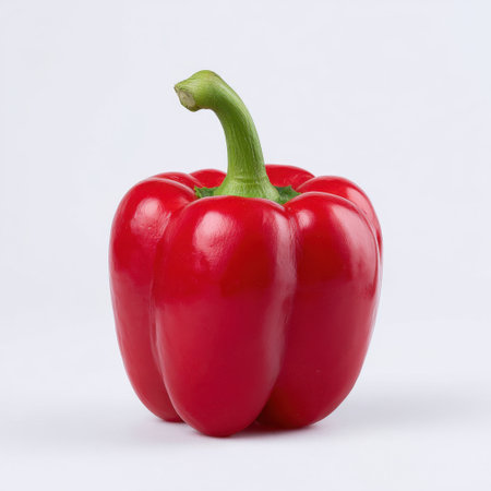 A vibrant red bell pepper stands alone against a white backdrop, embodying freshness and health, ideal for culinary use and nutrition-focused content.の素材