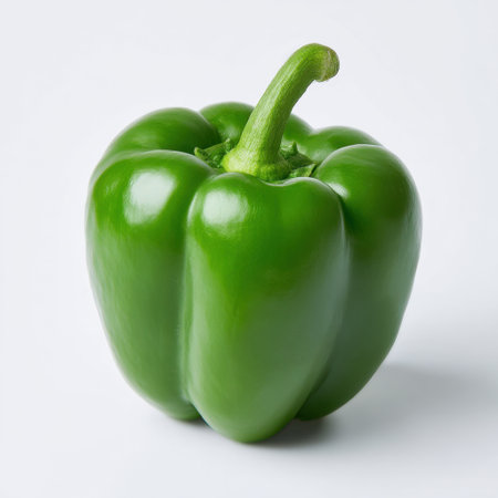 This image features a fresh green bell pepper on a white background, symbolizing health and vitality. Perfect for culinary and nutrition projects.の素材