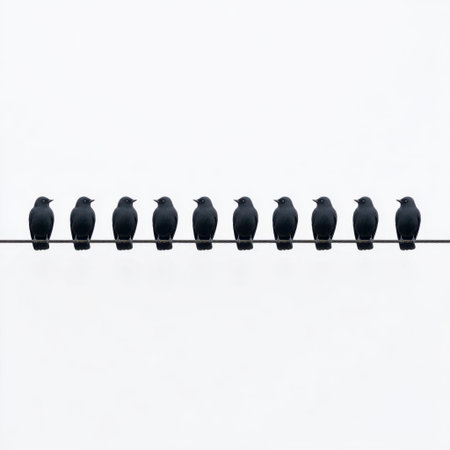 A minimalist image of black birds sitting in a perfectly aligned row on a thin wire. The soft gray background adds serenity and enhances the visual impact.の素材