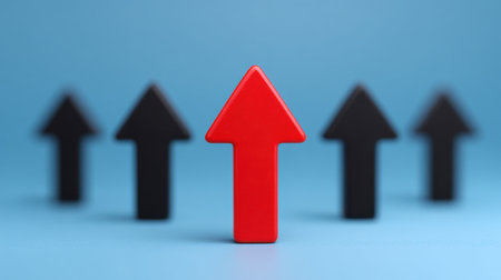 A striking red arrow positioned prominently among five black arrows on a soft blue background. This image signifies growth, direction, and the importance of standing out in the competitive business landscape.の素材