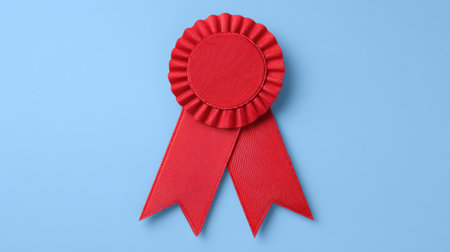This image features a classic red award ribbon with a smooth finish, set against a calming blue background, perfect for celebrating achievements.の素材