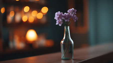 A stunning image featuring delicate purple flowers arranged in a clear glass bottle, set against a softly blurred background filled with warm bokeh lights, creating a cozy atmosphere.の素材