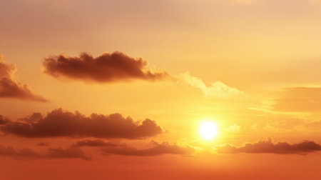 A breathtaking sunset features a warm blend of orange and yellow hues, casting a serene glow over soft clouds in the sky. Perfect for nature lovers.の素材