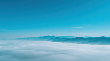 This stunning image captures a serene view of rolling mountains beneath a tranquil blue sky, blanketed by soft white clouds, creating a peaceful landscape.の素材