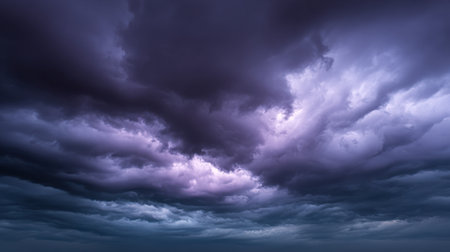 Captivating view of dark storm clouds swirling in vivid purple and gray shades, creating a dramatic atmosphere over a serene sea at dusk.の素材