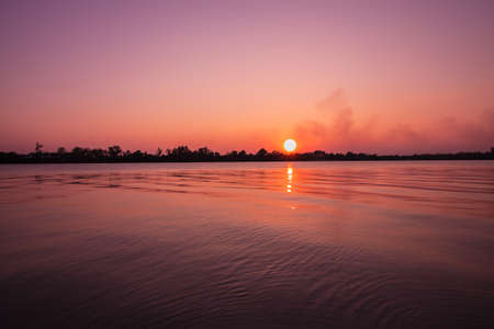 The beautiful reflection of sunset on the river in Thailandの写真素材