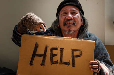 Jobless and homeless man asks for helps and share from passers-by as he suffers from coronavirus pandemic.の写真素材