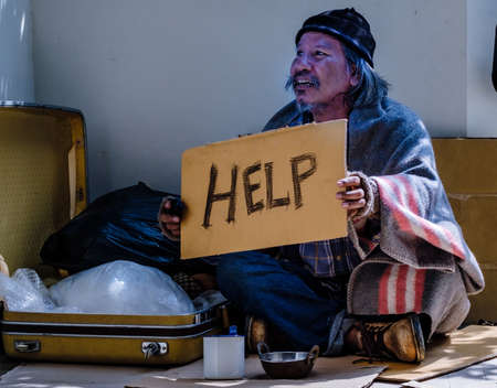 Due to the pandemic the homeless man is unemployed and lives by the sidewalk and asks for help from...