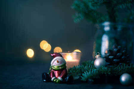 happy snowman with candle cones fir branches on the tableの写真素材