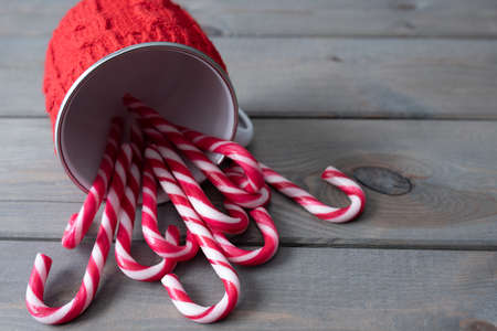 Candy canes and red knitted mug. Christmas background with copy space.の写真素材