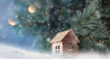 A little toy house under the fir tree.