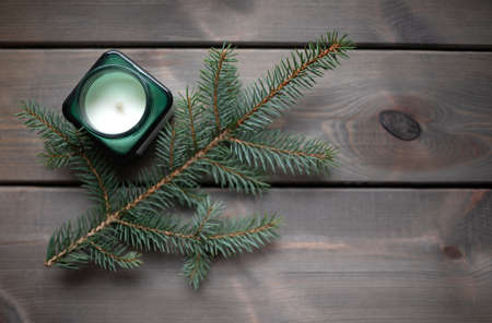Wooden background with candle and fir branch. Copy space.の写真素材