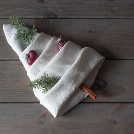 folded napkin as a fir tree and decorated with christmas decorationsの写真素材