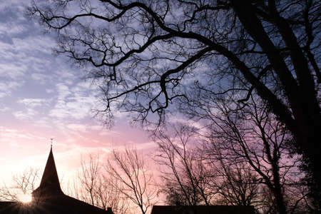 The silhouette of the church bell tower in sunrise