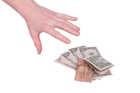 Hand reaching for money in a mousetrap isolated on white