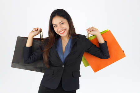 Isolated beautiful woman smiling and holding paper shopping bags on white background.の写真素材