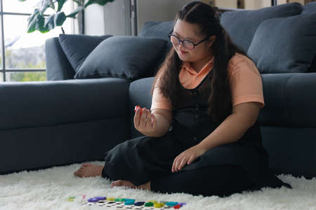 young girl is having fun practicing and learning with toys in the living room to develop her skillsの写真素材