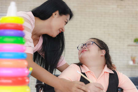 young girl is having fun practicing and learning with toys at home with her mother to develop her skillsの写真素材