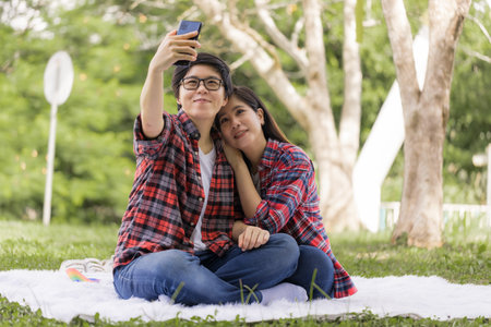 Asian Lesbian couples selfie-and resting in the park on vacation. LGBT concept.の写真素材