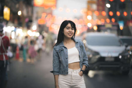 Beautiful Asian woman who has long hair travels to the festival at Yaowarat Chinatown in Thailand. Street photography of traveler woman at night.の写真素材