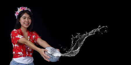 Young Asian women with ancient bowls Preserve the good culture of Thai people during the Songkran festival on black background. Thai New Year, Family Day in Aprilの写真素材