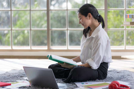 Young Asian women are using laptops to study online, work from home, and transact online during the...