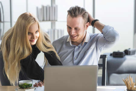 Young business man and woman working from home-office with morning sunshine. They are communicating in social network and searching information online.の写真素材