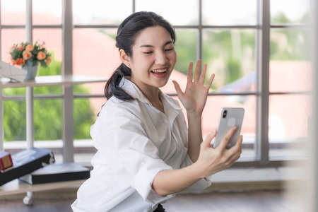 Young Asian women are using laptops and smart phone to study online, work from home, and transact...