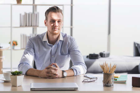 Portrait of young man working from home-office with morning sunshine.の写真素材