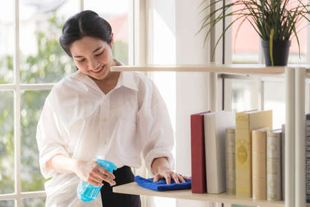 A long-haired Asian woman is cleaning room with an antiseptic. Activities to do at home while detained at home.の写真素材
