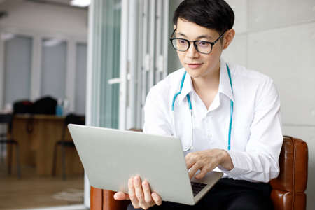 Male doctors in uniform are using laptops for medical work at modern hospital. empty monitor for your design.の写真素材