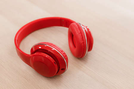 Red wireless headphone on wooden table. hobby and love music concept.の写真素材
