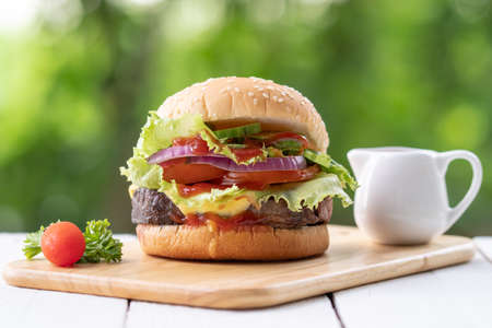 Tasty burger on cutting bord with bokeh backgroundの写真素材