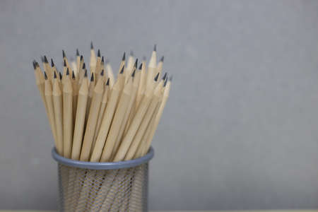 Many pencils are placed in a small basket against the cement wall background. back to school concept.の写真素材