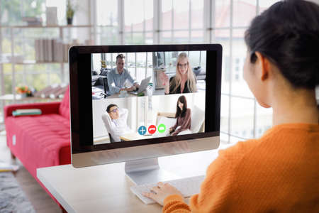 Back view of a businesswoman talking to a multi-ethnic colleague about a video-based business...